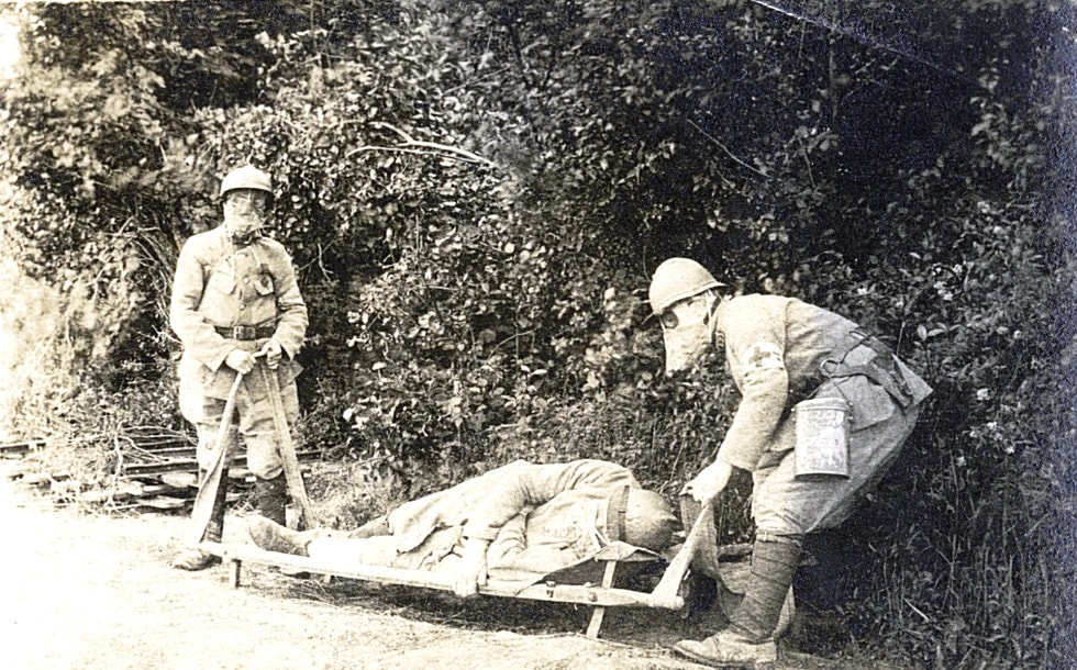 Blessé sur civière avec masque à gaz. Photographie de Georges Michaux. Sans date. Archives nationales, 700AP/6/PA_180