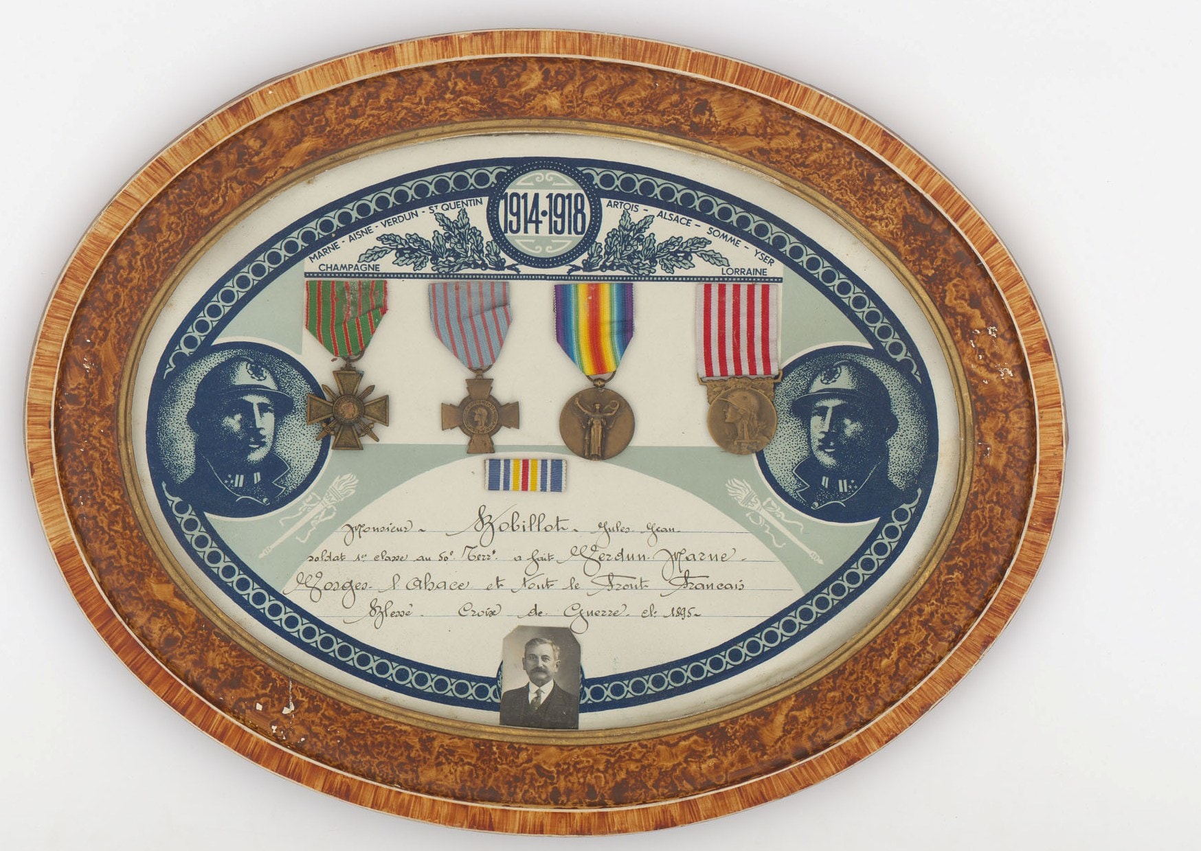 Cadre avec photo et médailles de Jules Bobillot, 50e RI. De gauche à droite : croix de guerre 1914-1918, croix du combattant, médaille interalliée 1914-1918, médaille commémorative de la guerre 14-18 ou « médaille des Poilus ». Archives nationales, 700AP/3/PA_016