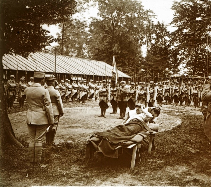 Le salut au drapeau, avec un blessé sur une civière. Collection de plaques de verre stéréoscopiques de Maurice Brun, 89e RI. Sans date. Archives nationales, 700AP/13/PA_341/1